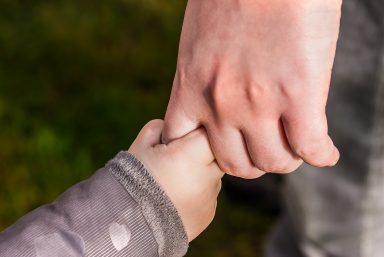 image of adult and child holding hands