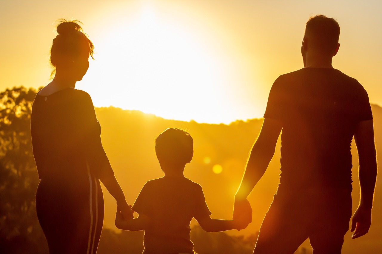 image of a man and a woman holding a childs hand