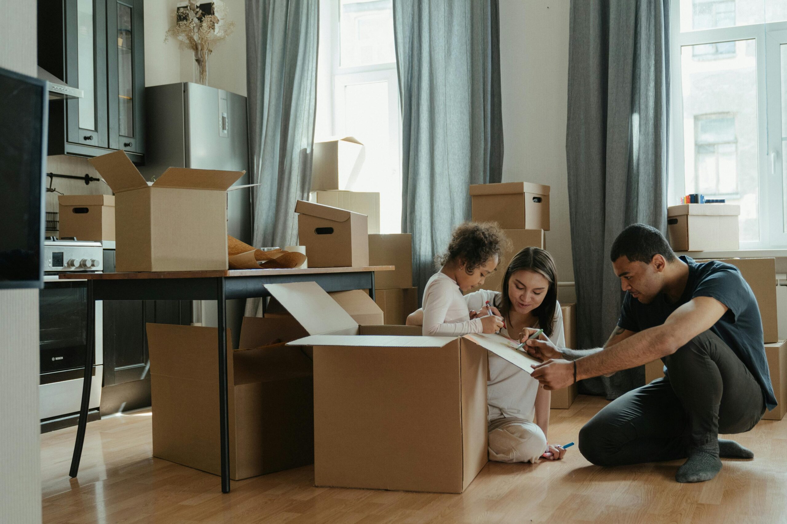 image of a family writing on cardboard moving boxes